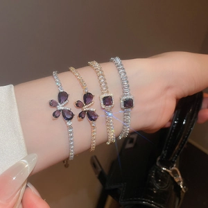 Détail de bracelets papillon élégants en zircon avec pierres violettes portés au poignet