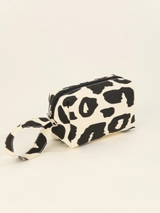 Detailed view of the cow print canvas makeup bag featuring a black zipper and side handle