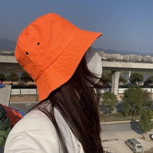 Neon orange cotton bucket hat for women featuring side eyelets and sun protection
