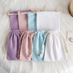 Detail of colorful cotton linen drawstring pouches in purple pink blue and white