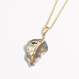 Close-up of a silver leaf pendant with golden veins on a fine gold O-chain necklace