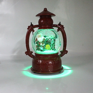 Close-up of lighted Christmas lantern with Santa, snowman, and green LED base glow