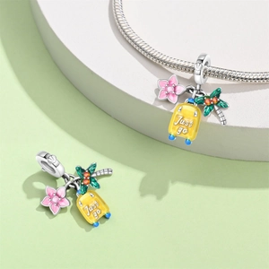 Silver charm bracelet with yellow suitcase, pink flower, and green palm tree pendant