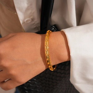 Détail du bracelet plaqué or 24 carats avec motif étoile et zircons sur un mannequin