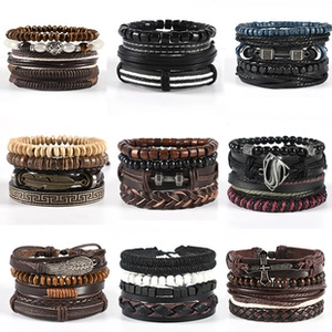 Detail view of multi-layer leather bracelets with wing, cross, and feather charms