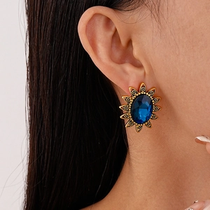 Detailansicht eines Vintage-Ohrrings mit dunkelblauem Ovalstein auf Goldbasis