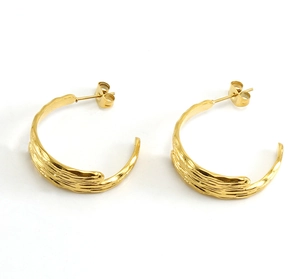 Macro detail of 18K gold plated earrings featuring organic bark texture and wavy design