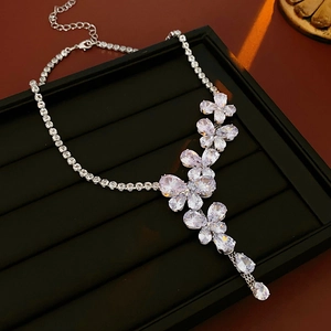 Macro shot of silver zircon flower necklace with teardrop pendant on black velvet