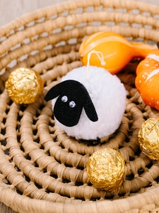 Vue rapprochée d'un mouton blanc en peluche fait main sur un panier tressé