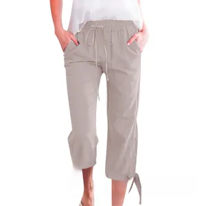 Detail of beige cotton linen cropped pants with drawstring waist and tied cuffs