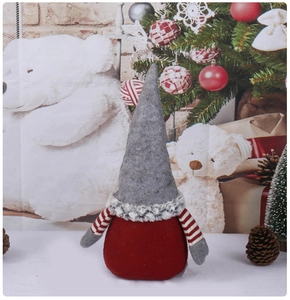 Dettaglio di uno gnomo di Natale con cappello a punta grigio e corpo in maglia rossa