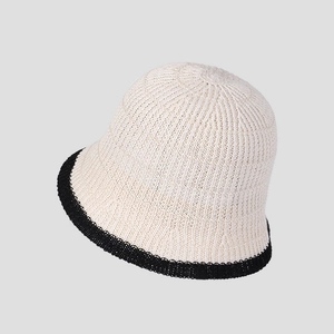 Detailed view of cream knit bucket hat with black contrast trim and ribbed texture