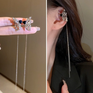 Détail de boucles d'oreilles clip nœud argentées avec chaînes sur un mannequin