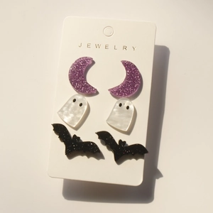 Halloween earring set with glittery acrylic moon, ghost and bat charms on white card