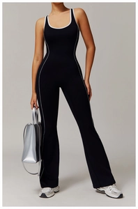 Detail eines schwarzen Yoga-Jumpsuits mit weißen Paspeln und ausgestelltem Beindesign