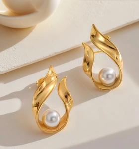 Detail of vintage gold twisted earrings featuring elegant white pearl center accents