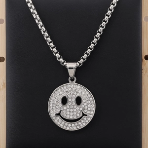 Dettaglio del ciondolo smiley argento con strass scintillanti su catena veneziana