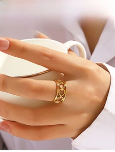 Detail of 18K gold镂空 heart ring worn while holding a coffee cup for stylish lifestyle look