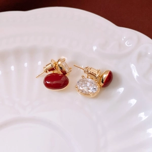Macro de boucles d'oreilles ovales rouges dorées avec cristaux brillants sur un plateau