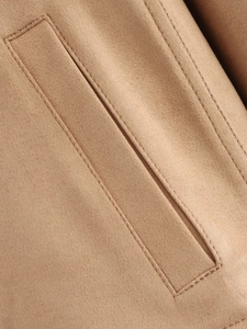 Detailed close-up of khaki faux suede fabric with precise double-needle stitching and pocket