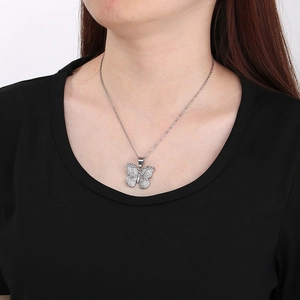 Detailed close-up of a silver butterfly pendant necklace with pavé crystals worn by a model
