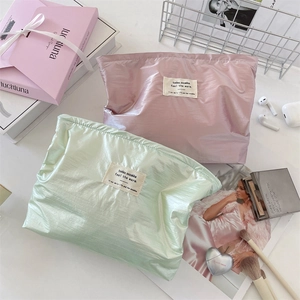 Close-up of pink and light green satin cosmetic bags with premium metallic texture
