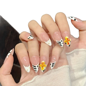 Handmade almond press-on nails with nude pink base, zebra patterns and 3D yellow flowers