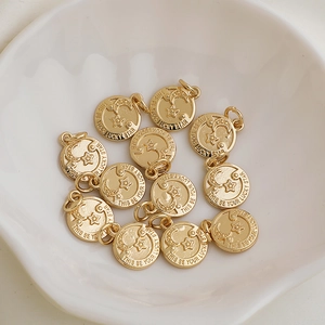 Close-up of gold star and moon round charms in a white ceramic bowl for DIY jewelry
