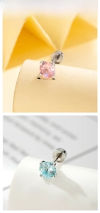 Detail of 5mm four-prong zircon stud earrings in pink and light blue with screw backs