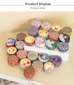 Close-up of scented soy candles in patterned tin cans with dried flower petals inside
