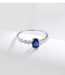 Macro detail of S925 sterling silver ring with blue oval gemstone and tiny diamonds