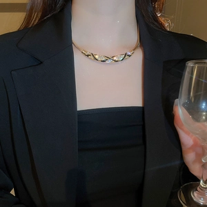 Detailed view of luxury gold curved necklace with black enamel and pavé rhinestones