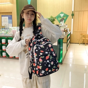 Close-up of cute strawberry print backpack featuring multiple functional zipper compartments