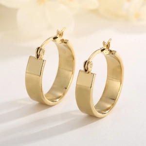 Close-up of minimalist gold-plated wide hoop earrings in high-quality stainless steel