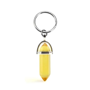 Yellow hexagonal crystal column keychain with polished silver metal ring on white background