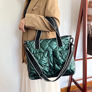 Quilted green puffer tote bag with wide black contrast straps for women's winter fashion