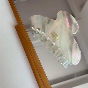 Macro shot of iridescent acetate hair claw clip with golden France Handmade lettering