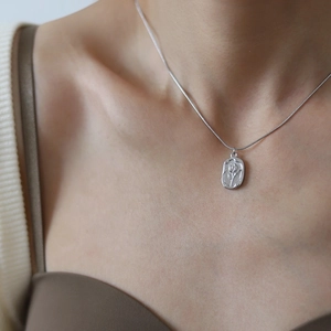 Collier argenté avec pendentif tulipe ovale et chaîne serpent porté par un mannequin