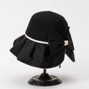 Close-up of black straw sun hat with large bow detail and elegant white trim finish