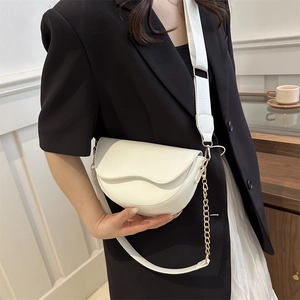 White minimalist PU saddle bag with wide woven strap and gold chain on black blazer model