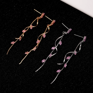 Detailed macro view of long tassel earrings with pink marquise zircon and twisted design