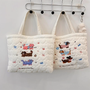 Close-up of white quilted tote bag featuring cute cat embroidery and heart textures