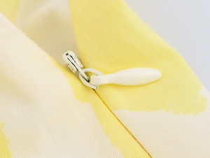 Detailed macro view of the invisible zipper and printed fabric texture on the midi skirt