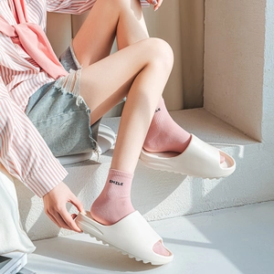 Off-white platform open-toe slides paired with pink cotton socks featuring SMILE embroidery