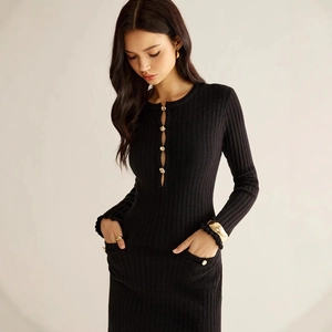 Détail de maille côtelée avec bouton doré décoratif sur une robe noire ajustée