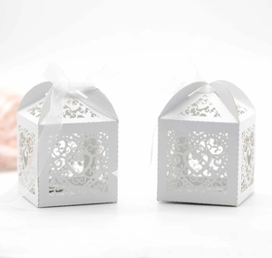 Detail of white laser-cut hollow heart candy box with elegant white organza ribbon bow