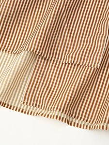 Close-up detail of the brown and white striped tencel fabric and hemline stitching