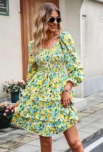 Detail of yellow floral dress featuring smocked bodice and tiered ruffle skirt