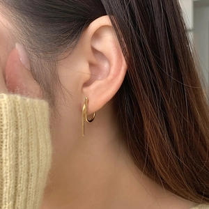 Close-up of minimalist gold S925 sterling silver geometric earrings worn on ear