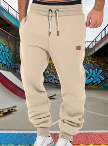 Detail of men's beige joggers showing the elastic waistband and adjustable drawstring